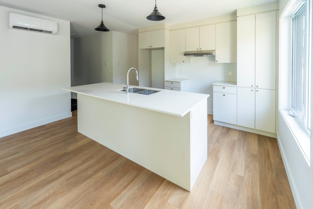 Cuisine moderne à aire ouverte avec îlot et comptoir-lunch dans un condo neuf à Magog - Gestion Floria