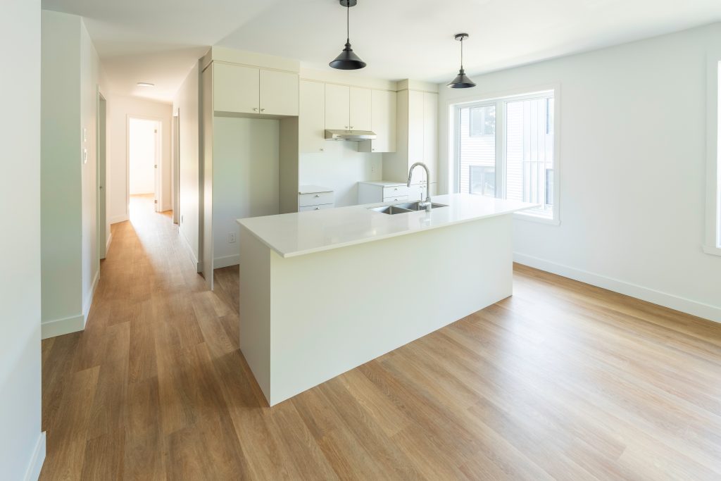 Cuisine moderne à aire ouverte avec îlot et comptoir-lunch dans un condo neuf à Magog - Gestion Floria