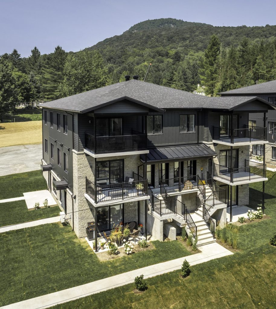 Vue aérienne d'un immeuble de condos modernes au pied de la montagne à Magog - Gestion Floria