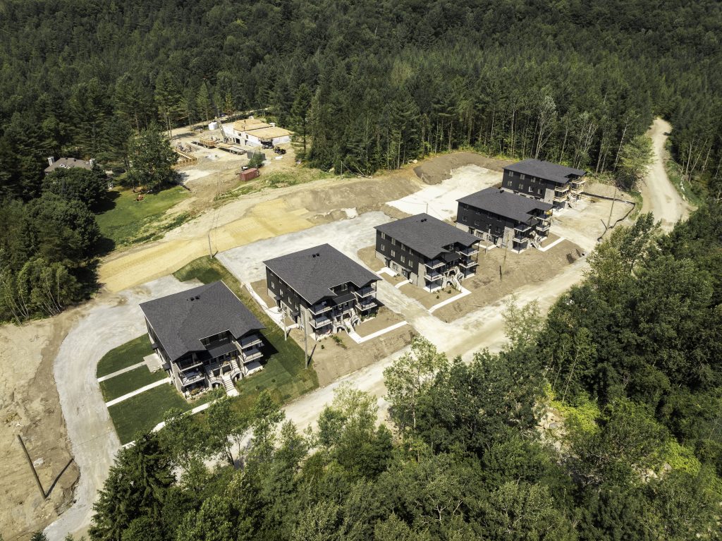 Vue aérienne d'un immeuble de condos modernes au pied de la montagne à Magog - Gestion Floria