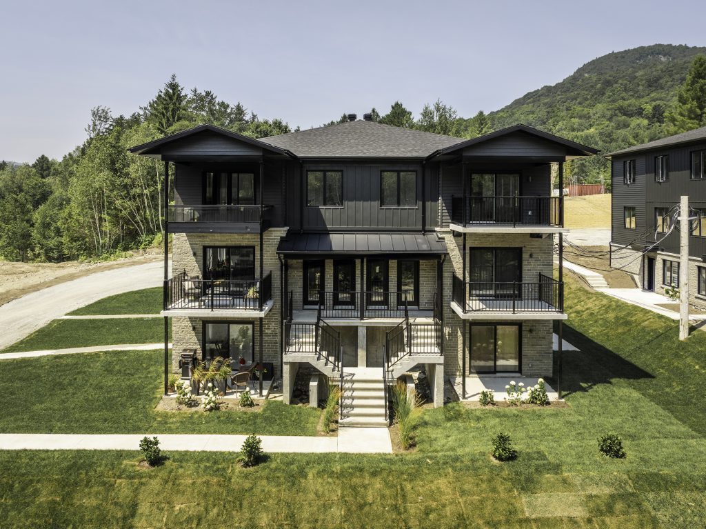 Vue aérienne d'un immeuble de condos modernes au pied de la montagne à Magog - Gestion Floria