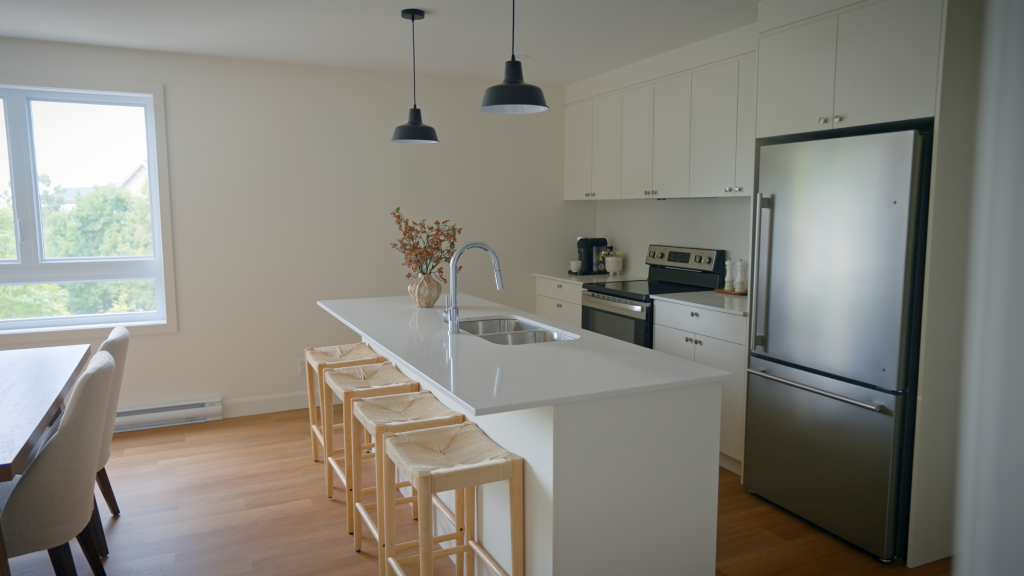 Cuisine moderne à aire ouverte avec îlot et comptoir-lunch dans un condo neuf à Sherbrooke - Gestion Floria