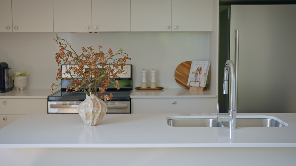 Aperçu d'une cuisine moderne avec comptoir en quartz blanc et robinetterie design dans un condo neuf à Sherbrooke - Gestion Floria